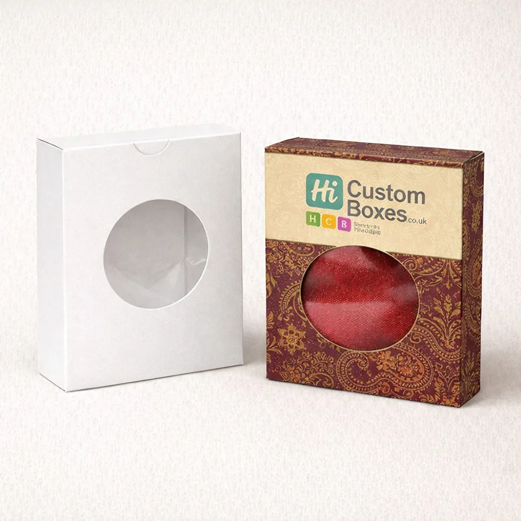 Two upright retail boxes with circular window cut-outs- showing a red shawl through the branded version- class=